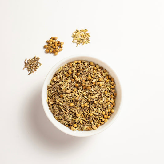 Ingredients of herbal CCF Tea Cumin Coriander and Fennel in a white bowl.