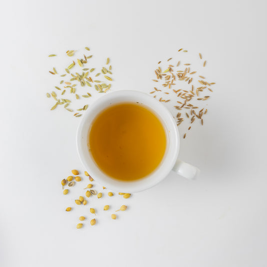 Ayurvedic CCF tea for digestion on a white background with the organic ingredients of cumin, coriander and fennel
