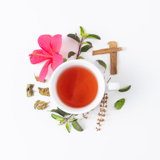 Gymnema tea blend for blood sugar brewed in a cup. the ingredients of this tea are displayed outside the cup on a white background and include organic gymnema, tulsi, hibiscus and cinnamon