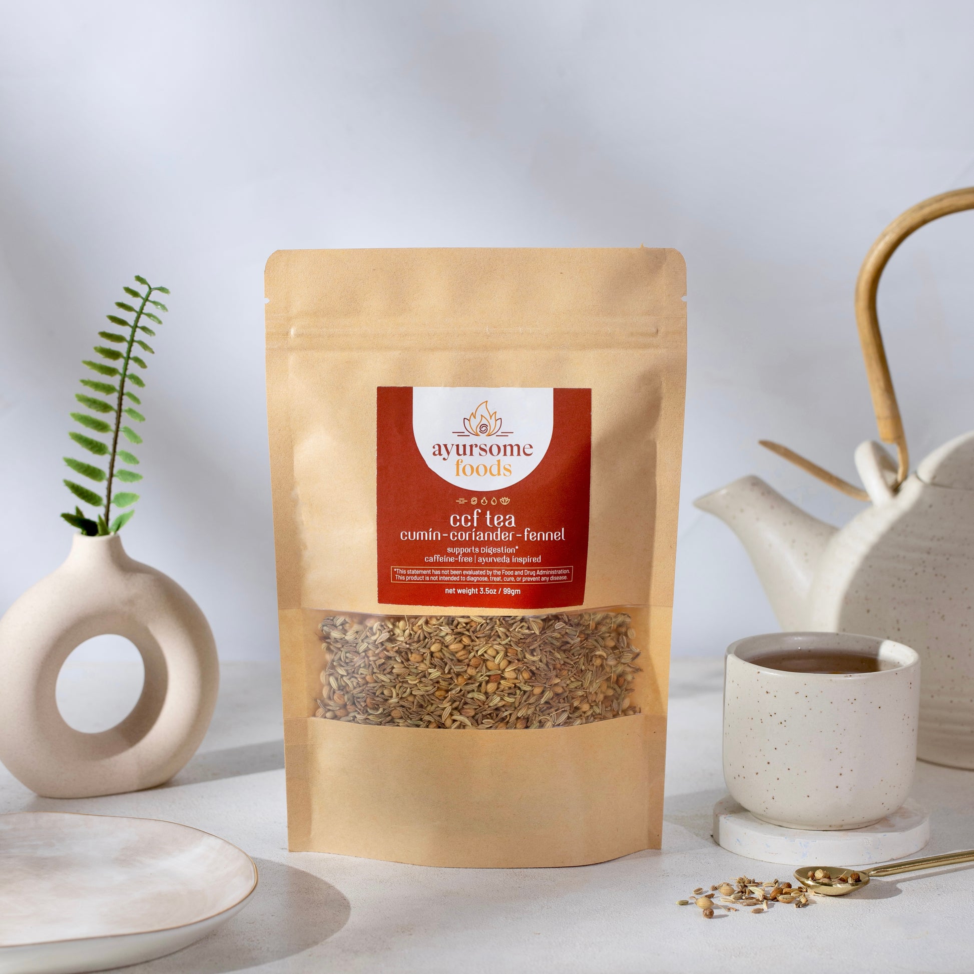 A pack of loose leaf CCF tea for digestion on a white background with the organic ingredients of cumin, coriander and fennel displayed